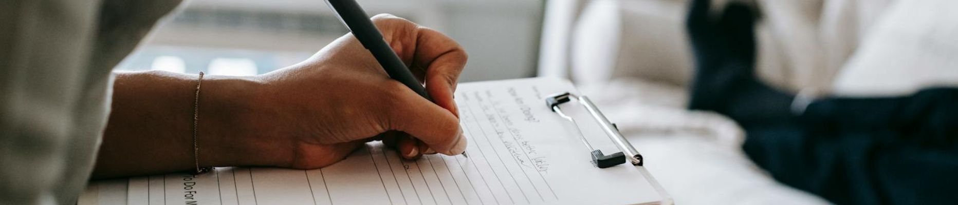 therapist taking notes on clipboard while filling out form during psychological appointment with anonymous client for blog post on therapy, medical insurance and diagnosis