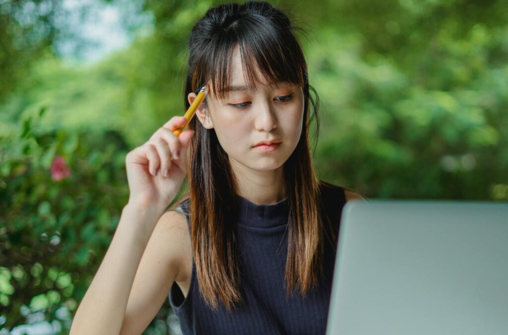 Photo by Zen Chung Thoughtful young Asian female student working on laptop for Treatment for Trauma using EMDR therapy in Maryland, Nevada and South Carolina.