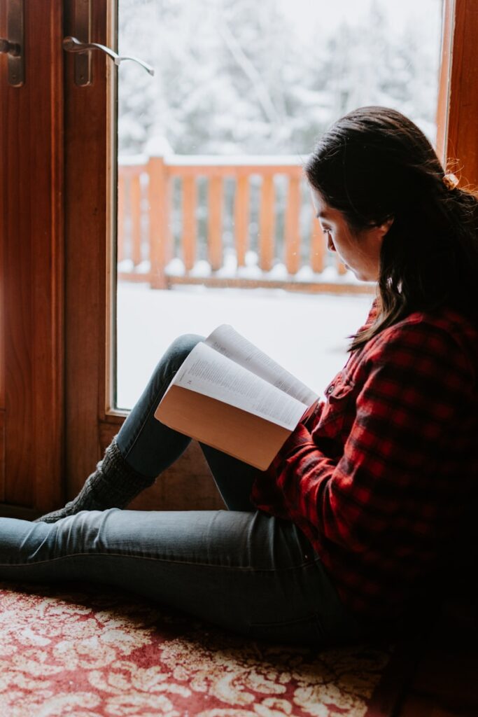 Photo by Kelly Sikkema woman in red and black striped long sleeve shirt and blue denim jeans sitting down for my approach to trauma therapy webpage