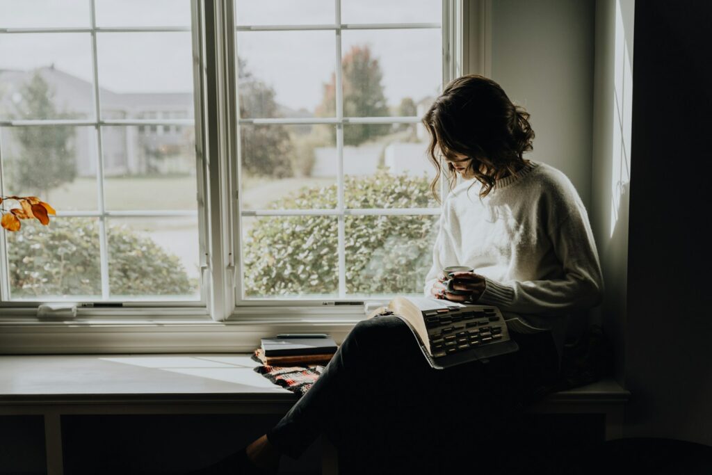 Woman reading by window after EMDR Intensive Therapy in Bethesda.