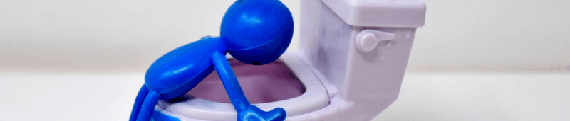 Blue toy figure hovering over toilet representing emetophobia