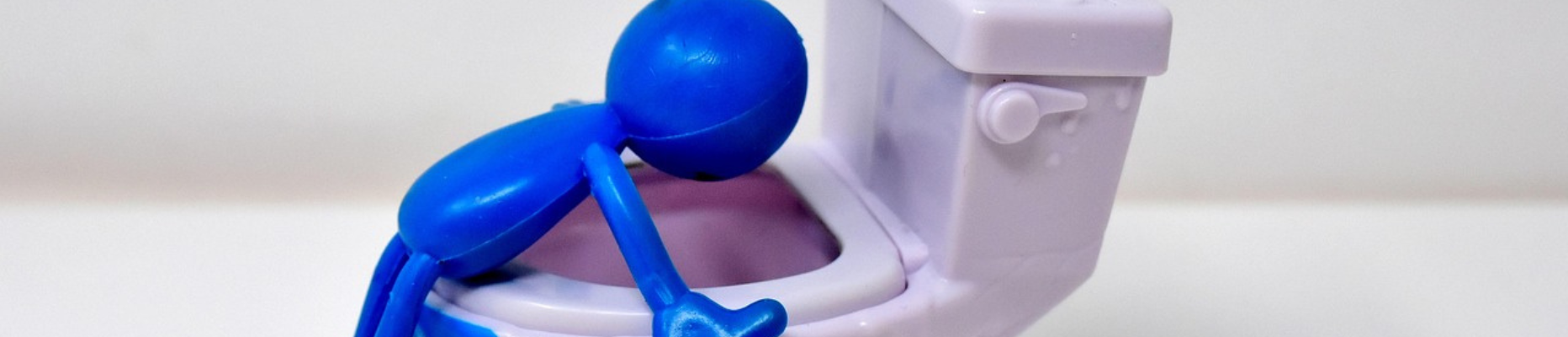 Blue toy figure hovering over toilet representing emetophobia