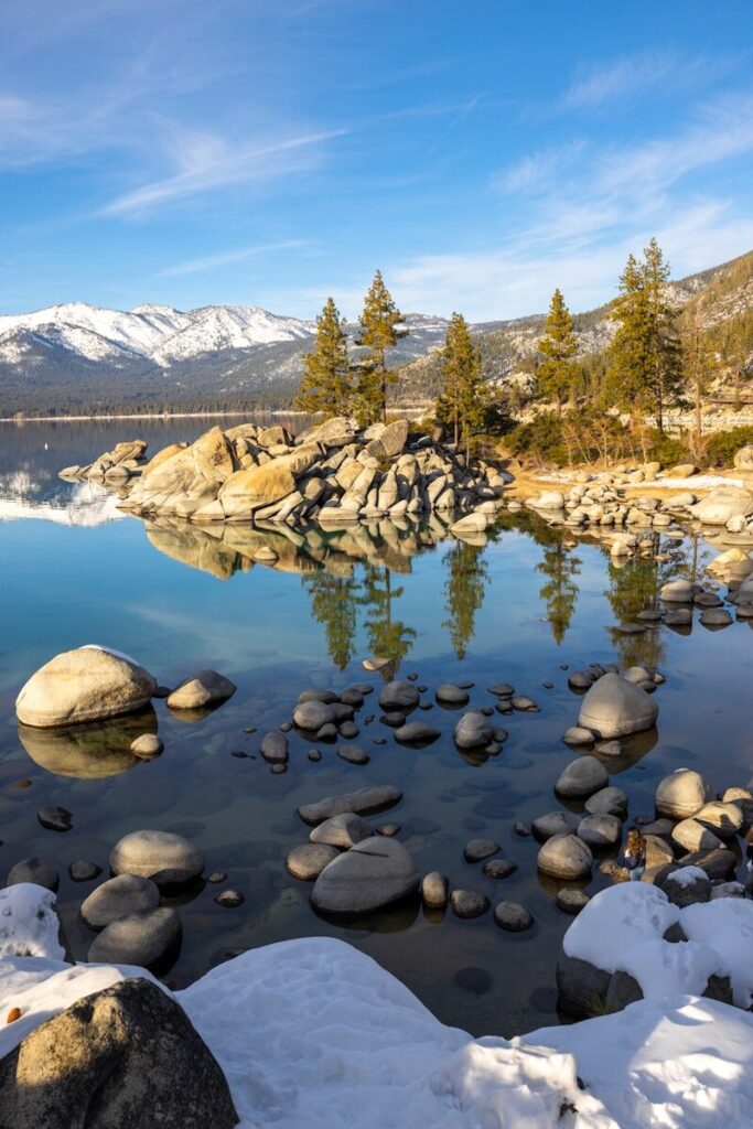 a mountain lake surrounded by snow covered rocks